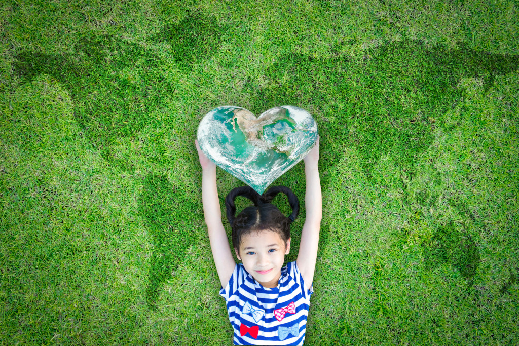 child carrying a heart shaped earth