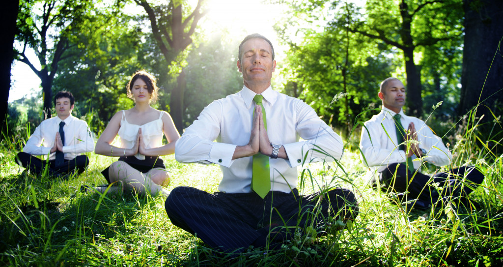 employees meditating in the woods
