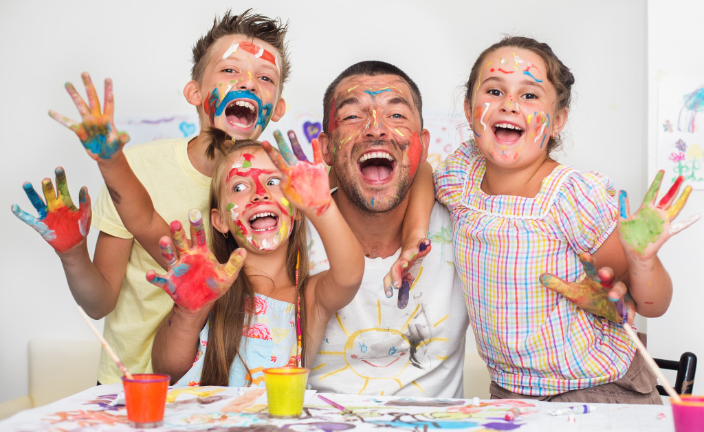 A father playing with paint with his children